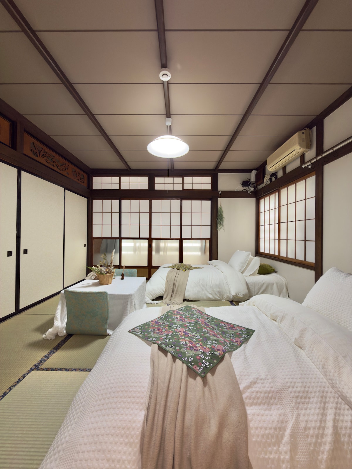 六合居 Rikugo Valley の和室寝室。障子から光が入り、低いテーブルと寝具を備える空間